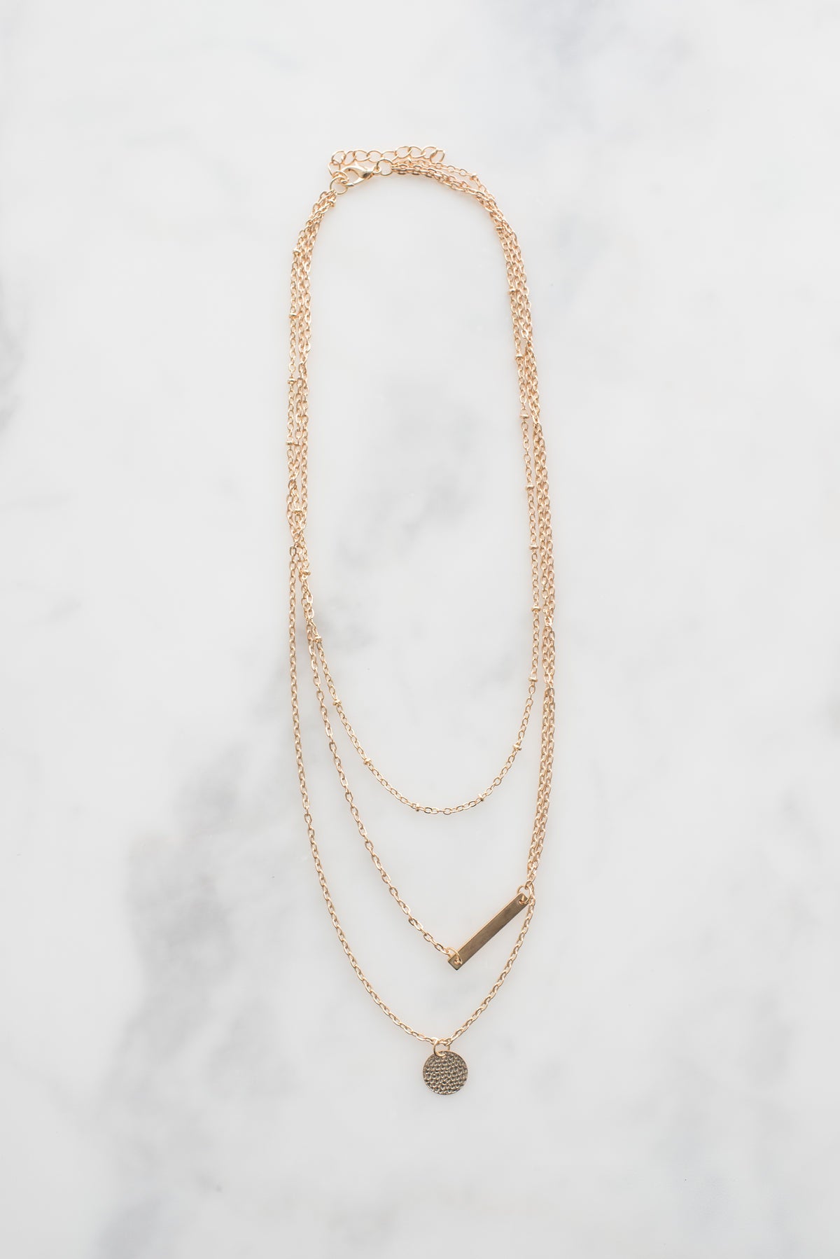 Dainty gold pendant necklace on display