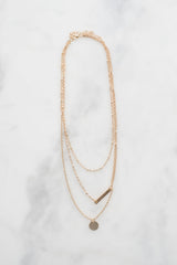 Dainty gold pendant necklace on display